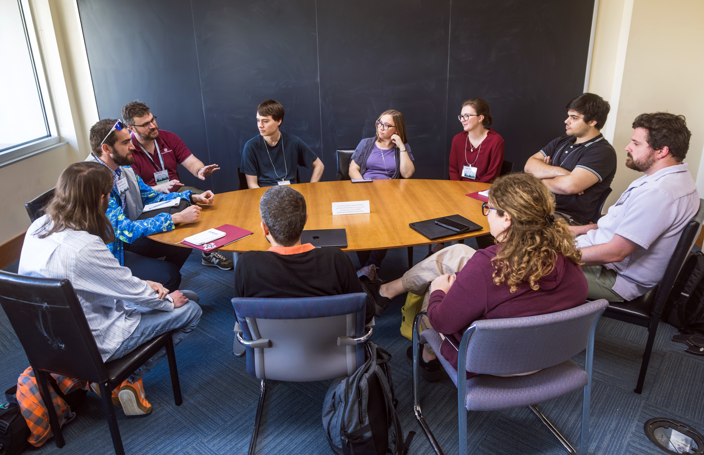 Texas A&M physicist Dr. Philip Adsley (third from left, wearing maroon) leads a group breakout discussion following the CeNAM Frontiers 2026 unconferencing session, a hallmark of the annual event.