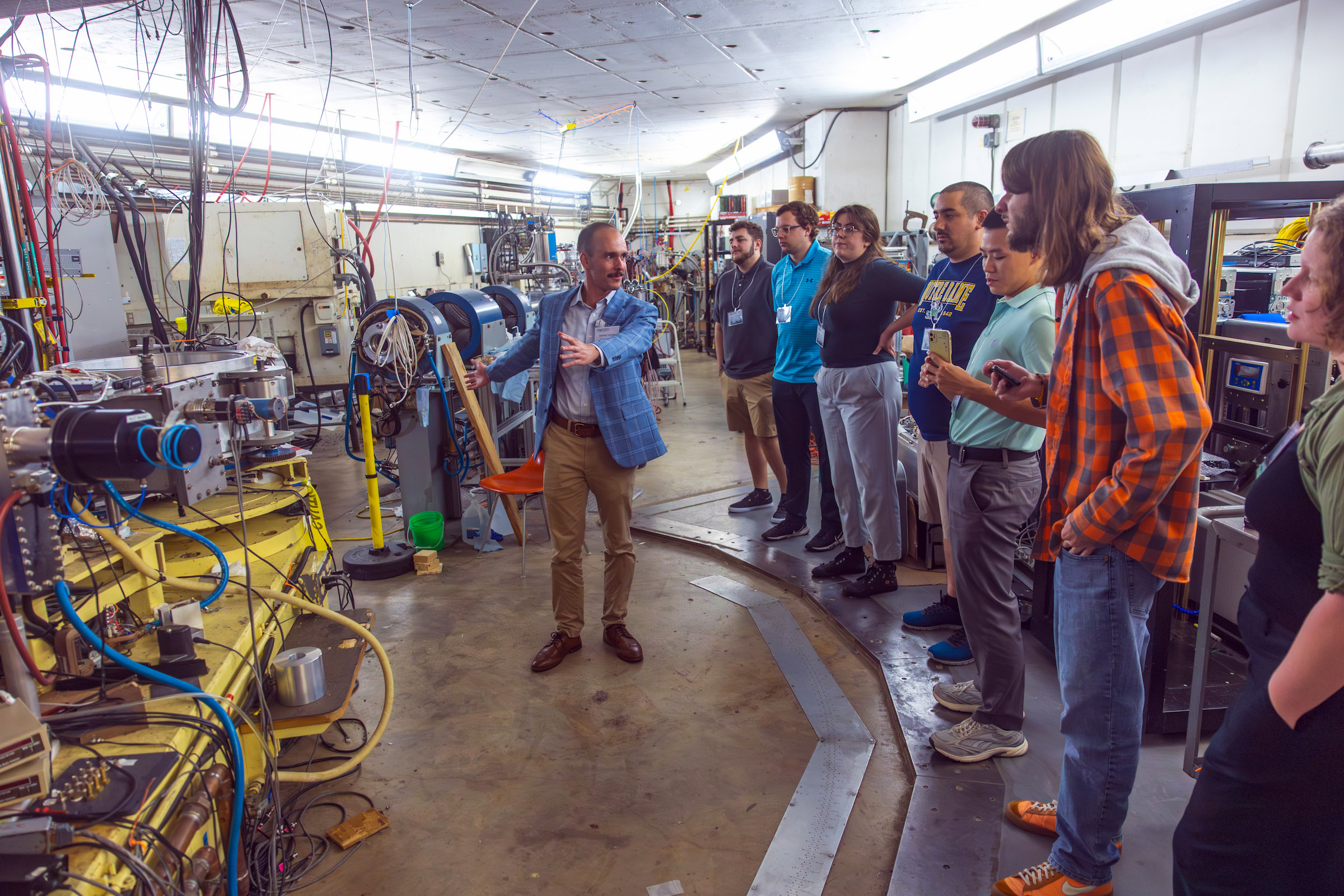 Texas A&M physics graduate student Anthony Lestone (left) leads CeNAM Frontiers 2026 attendees in a tour of the Cyclotron Institute. | Image: Chris Jarvis, Arts & Sciences Marketing & Communications