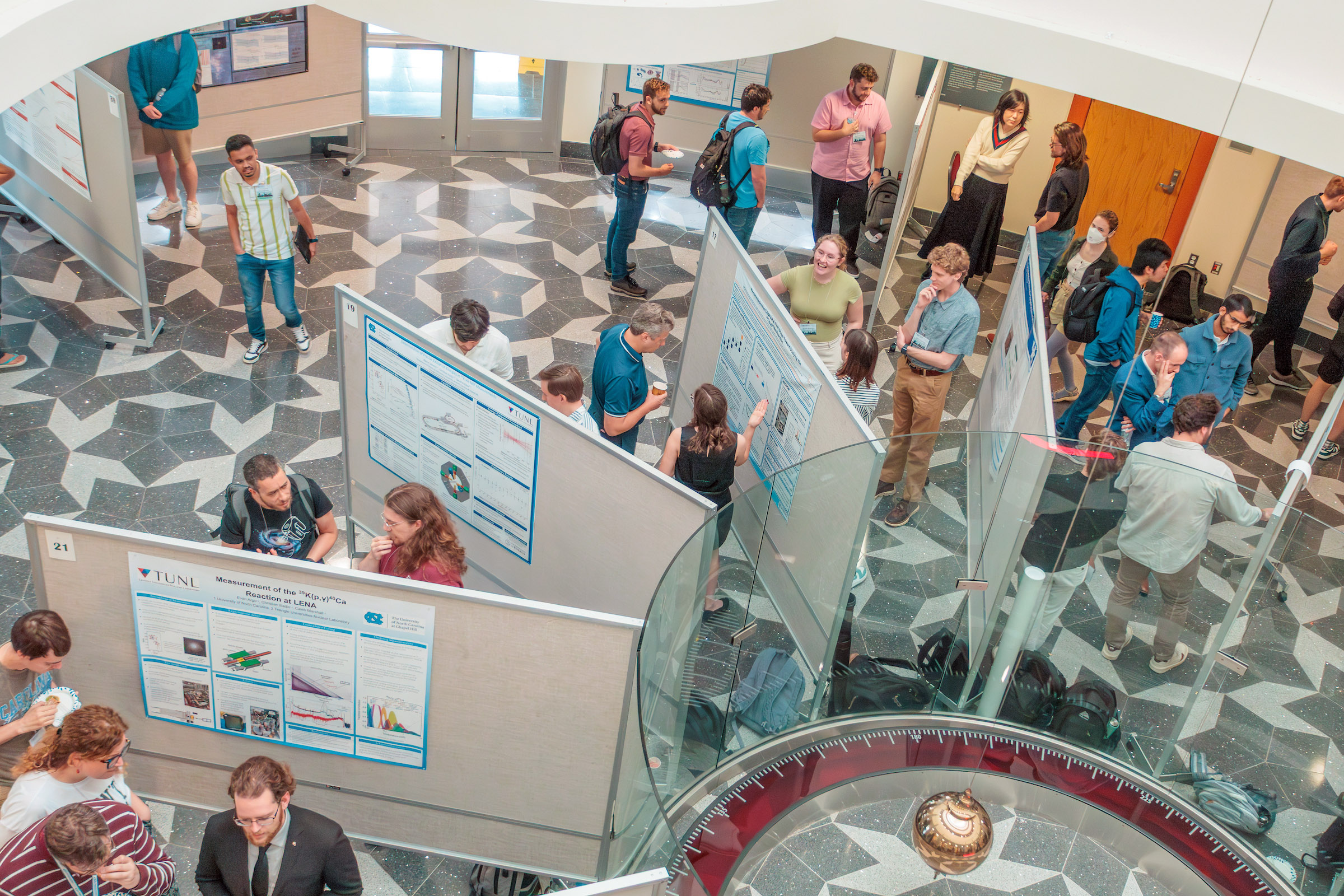 Graduate students present their research during the CeNAM Frontiers 2026 poster session in Penrose Plaza within the George P. and Cynthia Woods Mitchell Institute for Fundamental Physics and Astronomy.